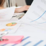 Professionnels analysant des graphiques et documents financiers pour élaborer un business plan détaillé.