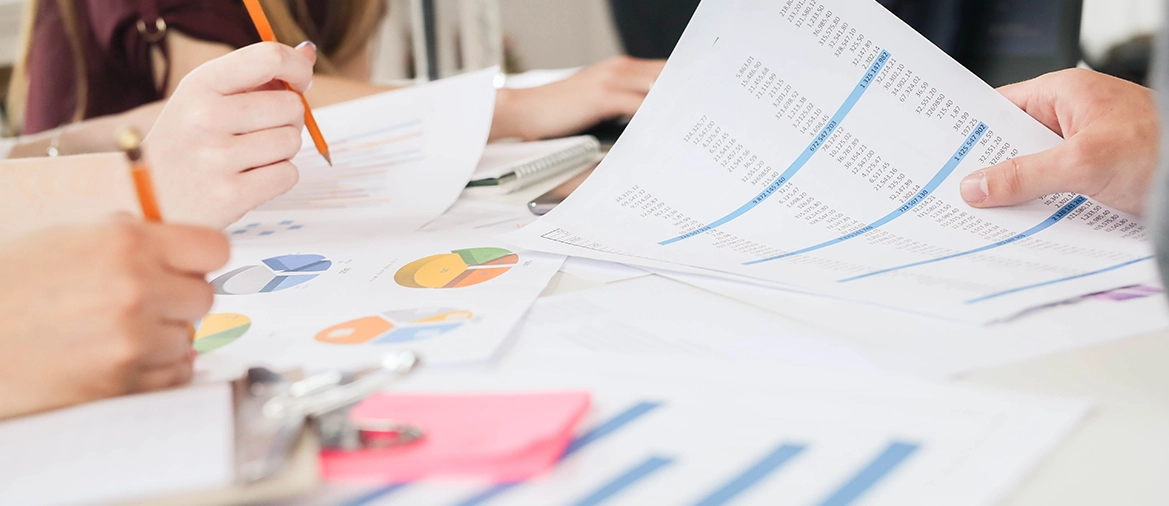 Professionnels analysant des graphiques et documents financiers pour élaborer un business plan détaillé.