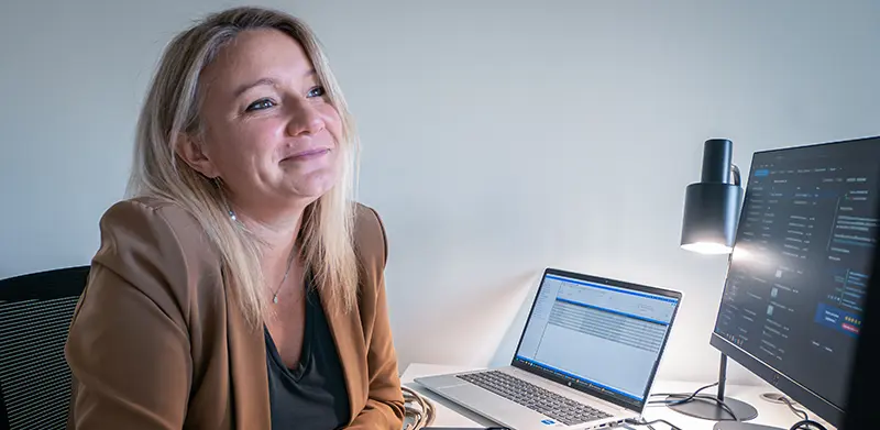 Collaboratrice Capeos souriante à son poste de travail à Cesson-Sévigné